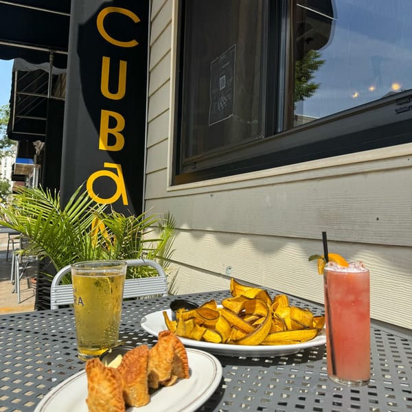 Cuban appetizers and drinks on an outdoor patio table at CubaNu Restaurant & Lounge.